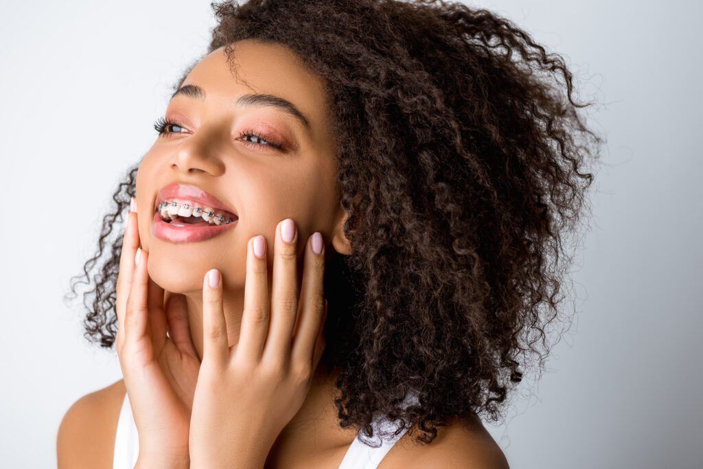 Young person with curly hair smiling.